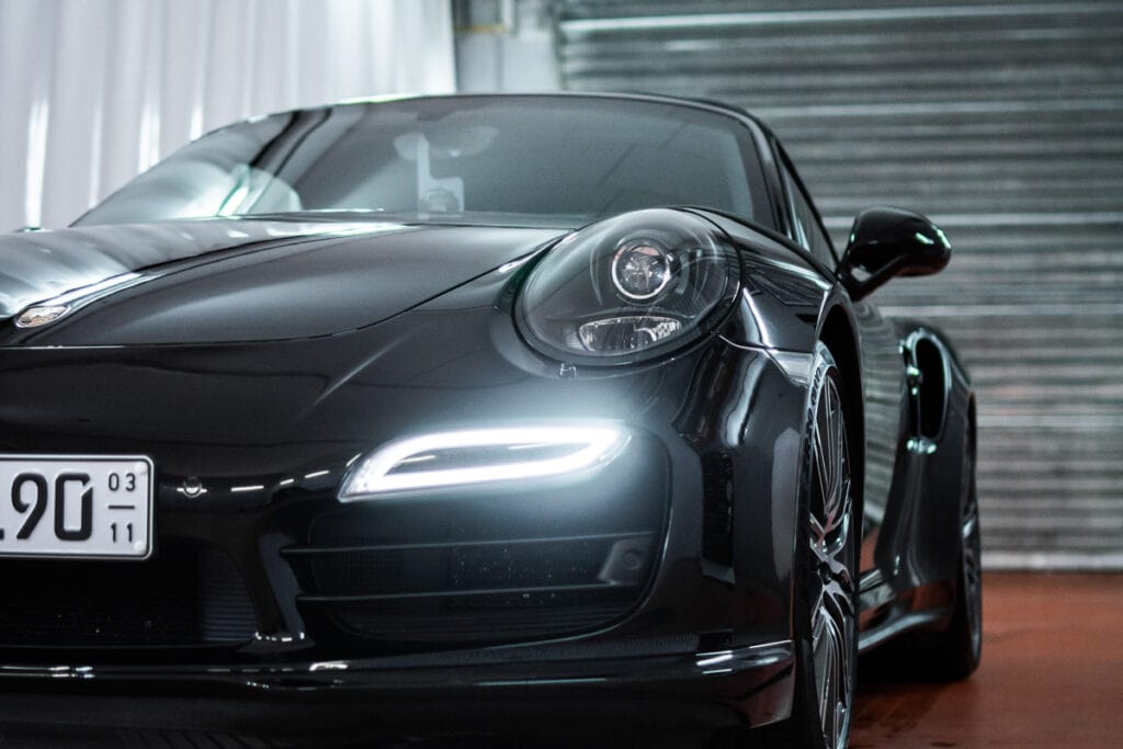 Ein schwarzer Porsche 911 GTS parkt in einer Garage mit Lackschutzfolierung.