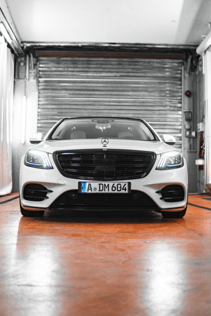 Eine weiße Mercedes S-Klasse parkt in einer Garage für Smart Repair Augsburg.